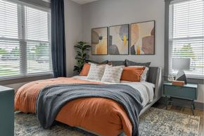Grandville apartment for rent - Large bed beside windows at The Commons at Rivertown apartments for rent in Grandville, MI.