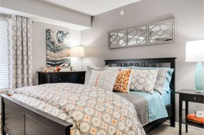 Ann Arbor apartment for rent - A bedroom with a large bed and a painting on the wall.