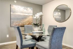 Ann Arbor apartment for rent - A dining room with a table set for four and a painting of a beach scene on the wall.