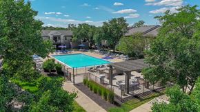 Ann Arbor apartment for rent - A pool surrounded by trees and a fence.
