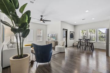 Tampa apartment for rent - A living room with a blue chair and a plant in a pot.
