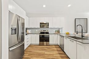 Tampa apartment for rent - A modern kitchen with white cabinets and stainless steel appliances.