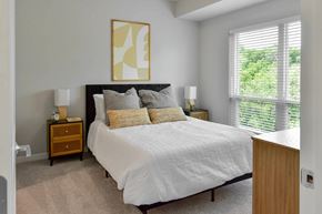 Cottage Grove apartment for rent - A bedroom with a large bed and a painting above it.
