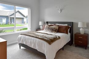 Rochester apartment for rent - A bedroom with a large bed and window view of outside at our apartments for rent in Rochester, MN.