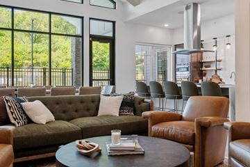 Rochester apartment for rent - A living room with a green couch and brown leather chairs.
