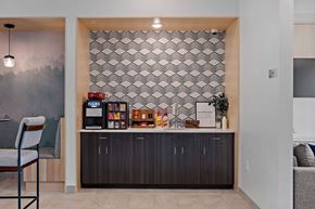Rochester apartment for rent - A modern kitchen with a wooden chair and a patterned wallpaper.
