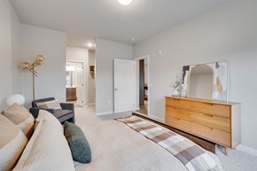West Saint Paul apartment for rent - A well-lit bedroom with a large bed and a dresser with a mirror at The Westlyn apartments for rent in West St. Paul, MN.