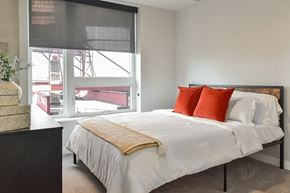 Minneapolis apartment for rent - A bedroom with a large bed and a window overlooking a construction site.