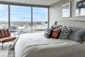 Skokie apartment for rent - A bedroom with a large bed and a view of the city at our apartments in North Chicago.