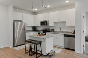 Lansing apartment for rent - A kitchen with white cabinets and a stainless steel refrigerator.