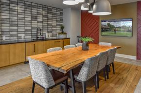 Lansing apartment for rent - A modern dining room with a wooden table and grey chairs.