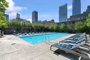 Chicago apartment for rent - A swimming pool with lounge chairs and a city skyline in the background.