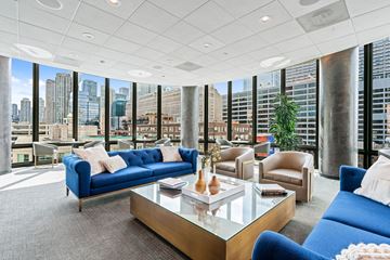 Chicago apartment for rent - A living room with blue couches and a glass coffee table.