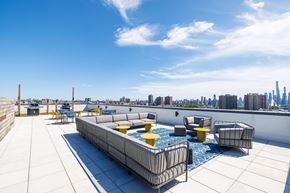 West New York apartment for rent - A rooftop patio with a hot tub and chairs.