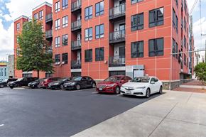 Richmond apartment for rent - A red building with cars parked in front.