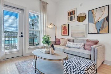 Williamsburg apartment for rent - A living room with a grey couch, a round table, and a painting on the wall.