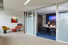 Seattle apartment for rent - A woman is sitting at a desk with a laptop in a modern office space.