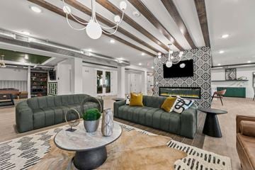 Fort Worth apartment for rent - A living room with a green sofa and a television on the wall.