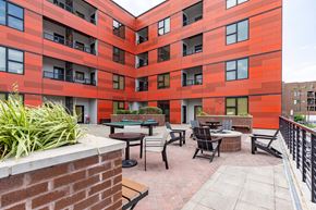 Richmond apartment for rent - A red building with a patio and chairs.