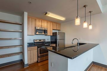 Richmond apartment for rent - A kitchen with a black countertop and wooden cabinets.