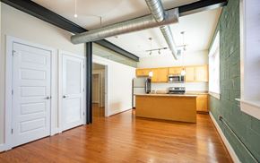 Richmond apartment for rent - A kitchen area with a wooden floor and white walls.