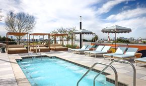 West Hollywood apartment for rent - A pool with a metal ladder and a row of sun loungers.