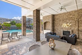 Mt. Pleasant apartment for rent - A patio with a table and chairs and a pool in the background.