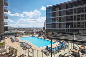 Phoenix apartment for rent - A swimming pool surrounded by lounge chairs and buildings.
