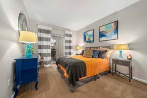 Peoria apartment for rent - A bedroom with a bed, nightstands, and a chair.