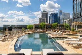 Austin apartment for rent - A pool area with chairs and a sign that says Silicon Labs.