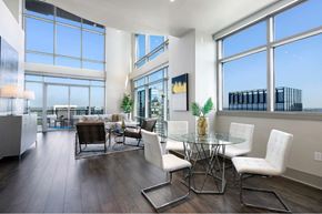 Austin apartment for rent - A modern dining room with a glass table and white chairs.
