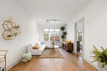Charlotte apartment for rent - A living room with a white couch and a wooden floor.