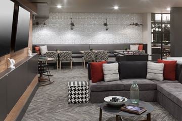 Denver apartment for rent - A modern living room with grey sofas and a patterned rug.