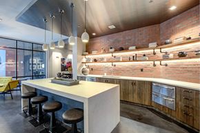 Raleigh apartment for rent - A modern kitchen with a white counter and black stools.