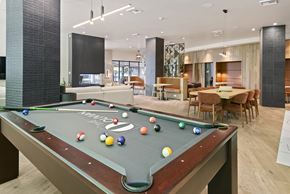 Seattle apartment for rent - A pool table is in the middle of a room with a dining table and chairs.