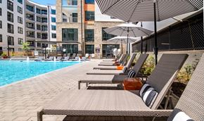 Decatur apartment for rent - A row of sun loungers are on the side of a pool.