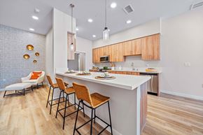 Los Angeles apartment for rent - A kitchen with a white counter and orange chairs.