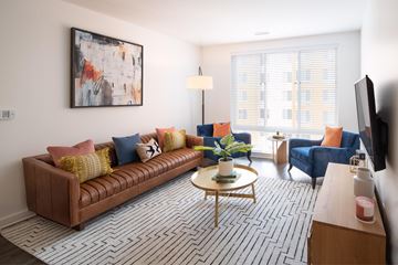 Alexandria apartment for rent - A living room with a brown couch, a coffee table, and a painting on the wall.