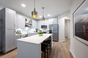 Orlando apartment for rent - A modern kitchen with white cabinets and a large island.at Corban Freedom Apartments, Orlando, FL