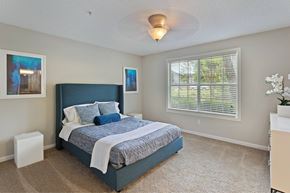 Sandy Springs apartment for rent - A bedroom with a large bed and a window with blinds.