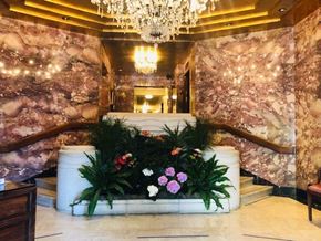 San Francisco apartment for rent - A large floral arrangement sits on a white planter in a marble hallway.
