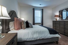Indian Trail apartment for rent - A bedroom with a bed, nightstand, and a lamp.
