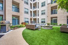 Houston apartment for rent - A patio with a fire pit and seating area in front of a building.