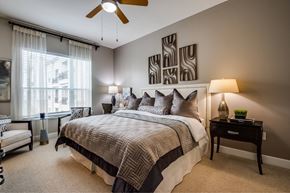 Houston apartment for rent - A bedroom with a large bed and a ceiling fan.