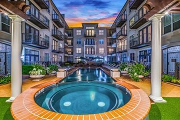 Houston apartment for rent - A swimming pool in the middle of a courtyard surrounded by buildings.