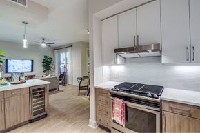 Houston apartment for rent - A modern kitchen with wooden cabinets and a stove top oven.