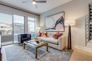 Houston apartment for rent - A living room with a blue rug and a painting on the wall.