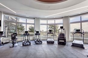 Houston apartment for rent - A gym with a row of treadmilers and elliptical machines.