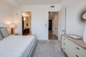 Houston apartment for rent - A bedroom with a large bed and a dresser.