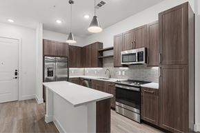 Richardson apartment for rent - A modern kitchen with dark wood cabinets and stainless steel appliances.